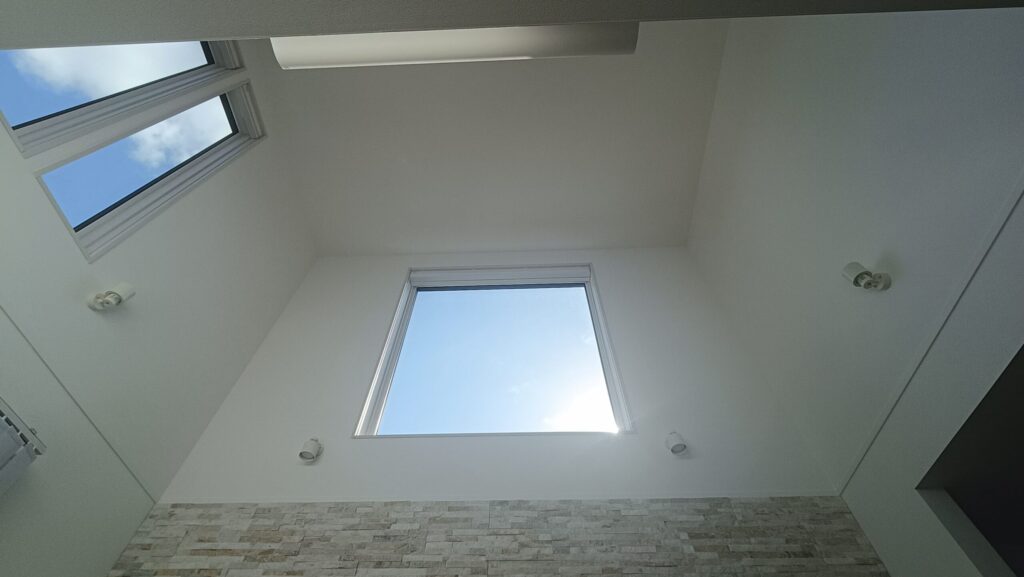 南面の大開口1枚窓と東面の高窓から自然光が降り注ぐ、一条工務店グランスマートの吹き抜けリビング。天井高5.1mの開放的な空間が広がる。