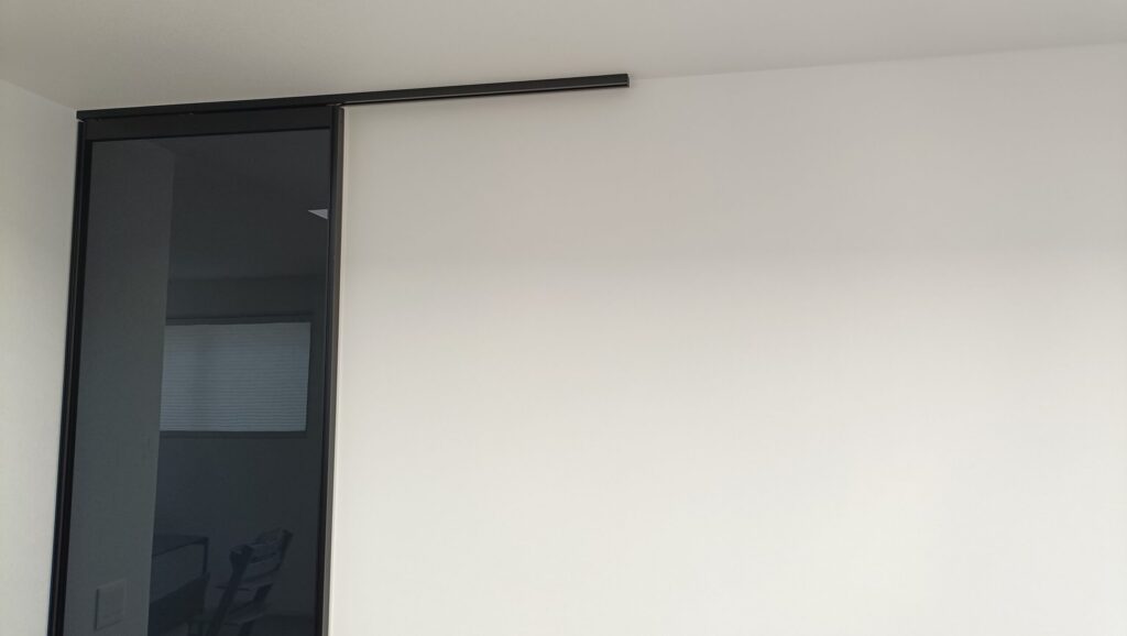 一条工務店グランスマートのリビングに採用した大栄建具のアクリルドア「CLEVA(クレバ)」。天井吊り仕様で床にレールがなく、透明感とバリアフリー性を両立している。